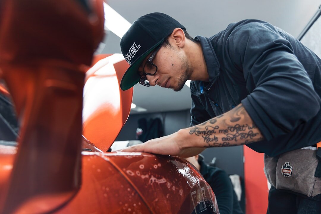 Professional technician inspecting a premium vehicle in a modern workshop