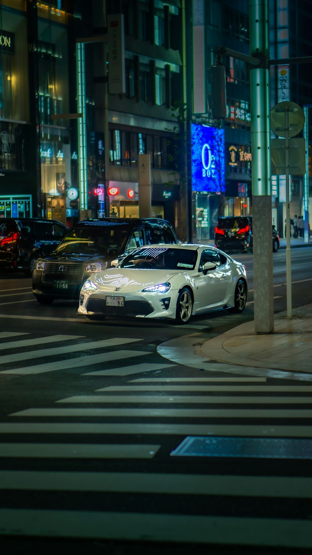 Modern Japanese car on a city street with neon signage