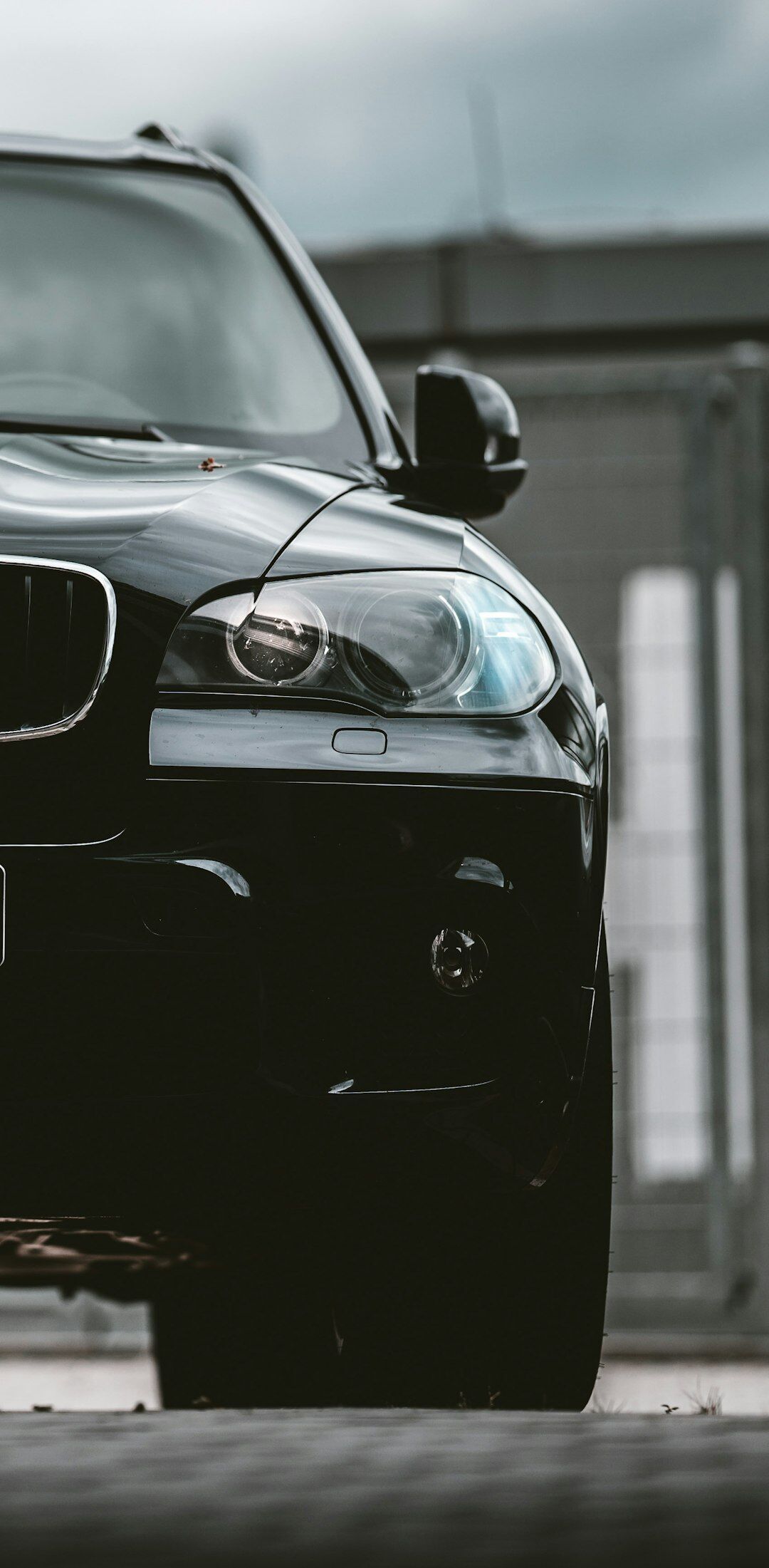 Black luxury SUV photographed in a dark editorial studio
