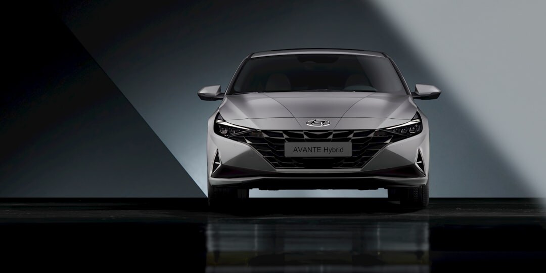 Silver premium sedan photographed in a dark studio with reflections